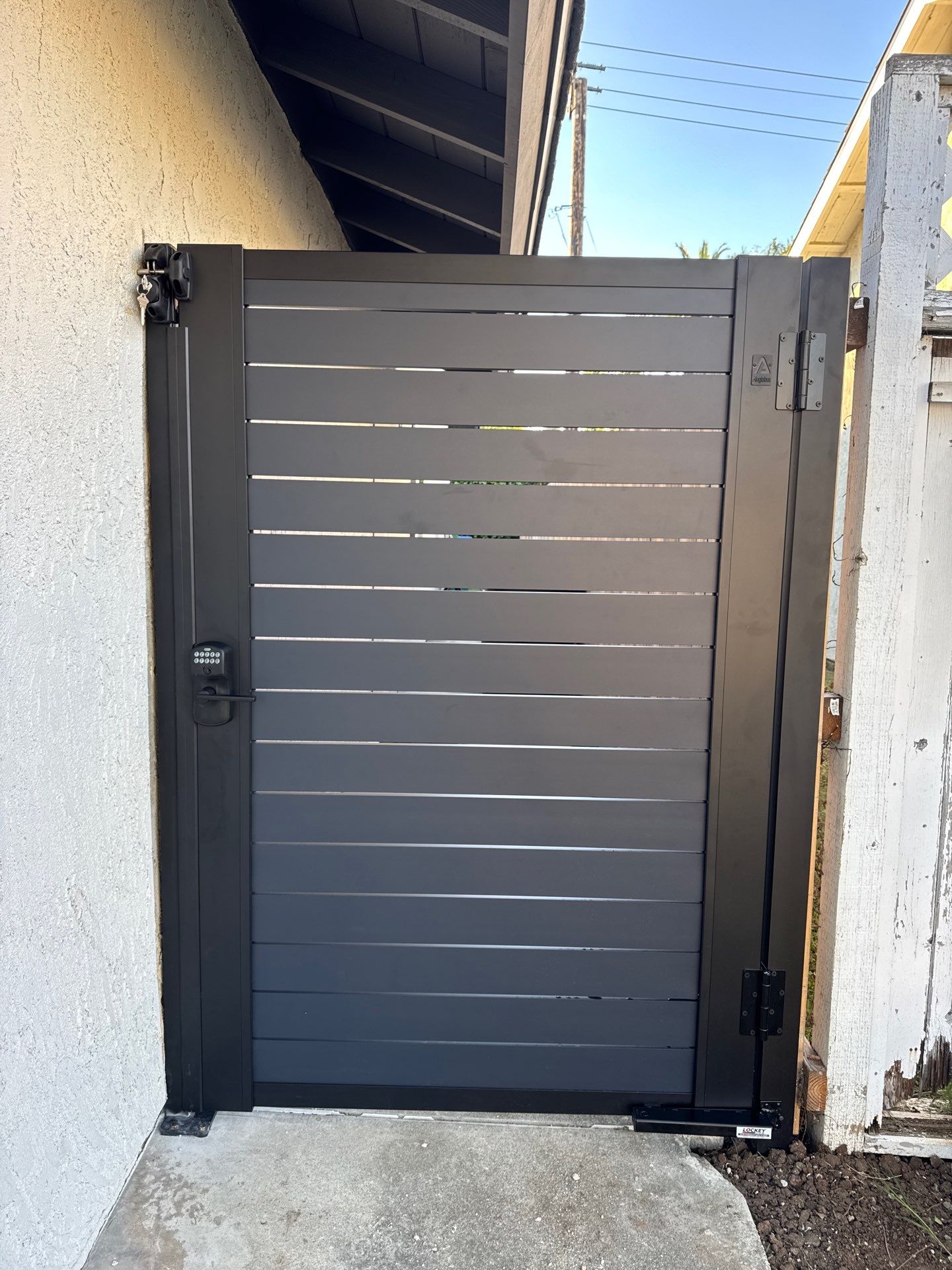 Real installation of Profile 40 aluminum gate at villa entrance with stone pillars