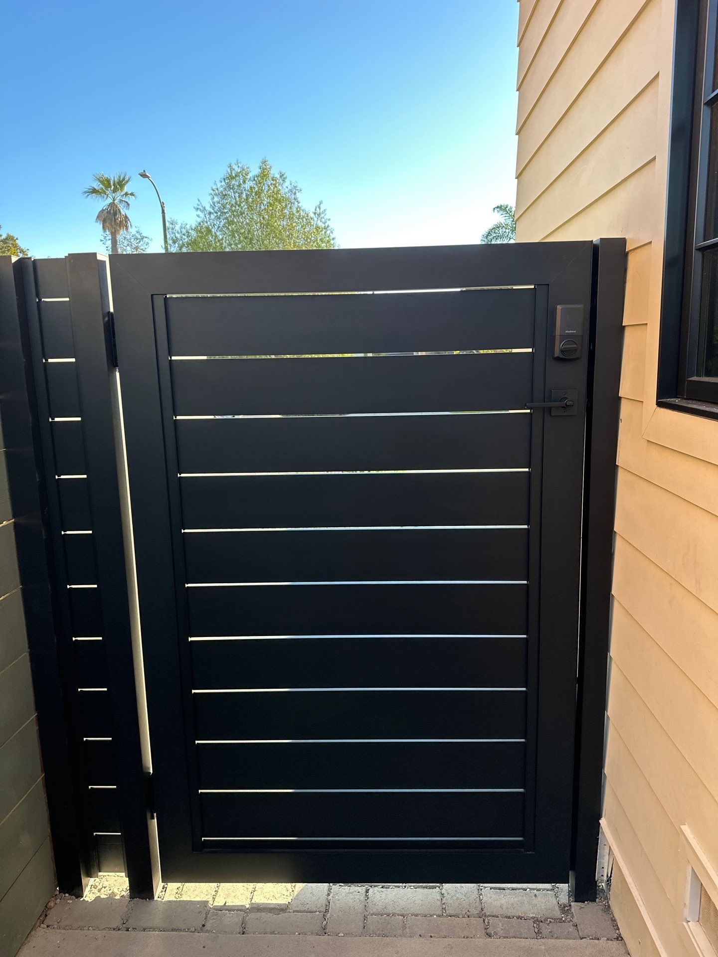 Profile 40 aluminum double swing gate installed at modern property with brick posts