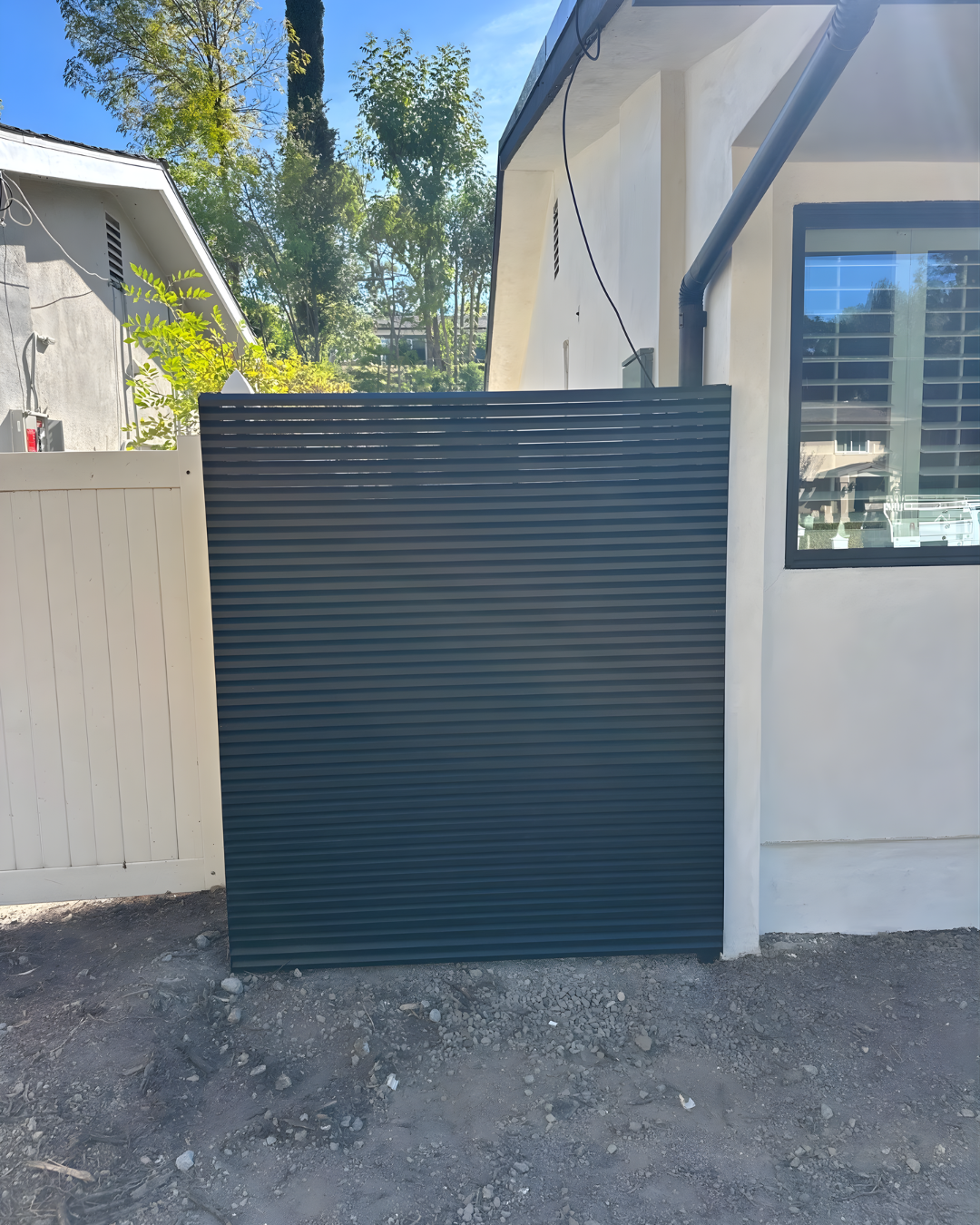 AeroLouver aluminum gate on-site installation at contemporary villa boundary