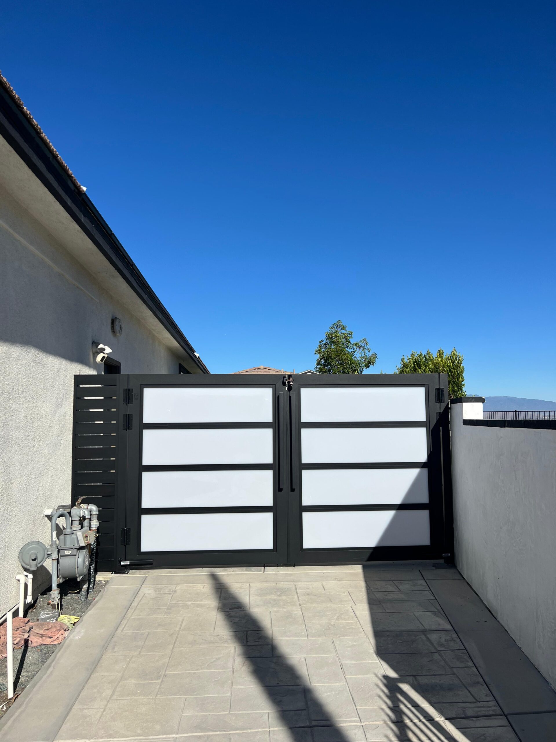 Real installation of aluminum plexiglass gate at residential property entrance
