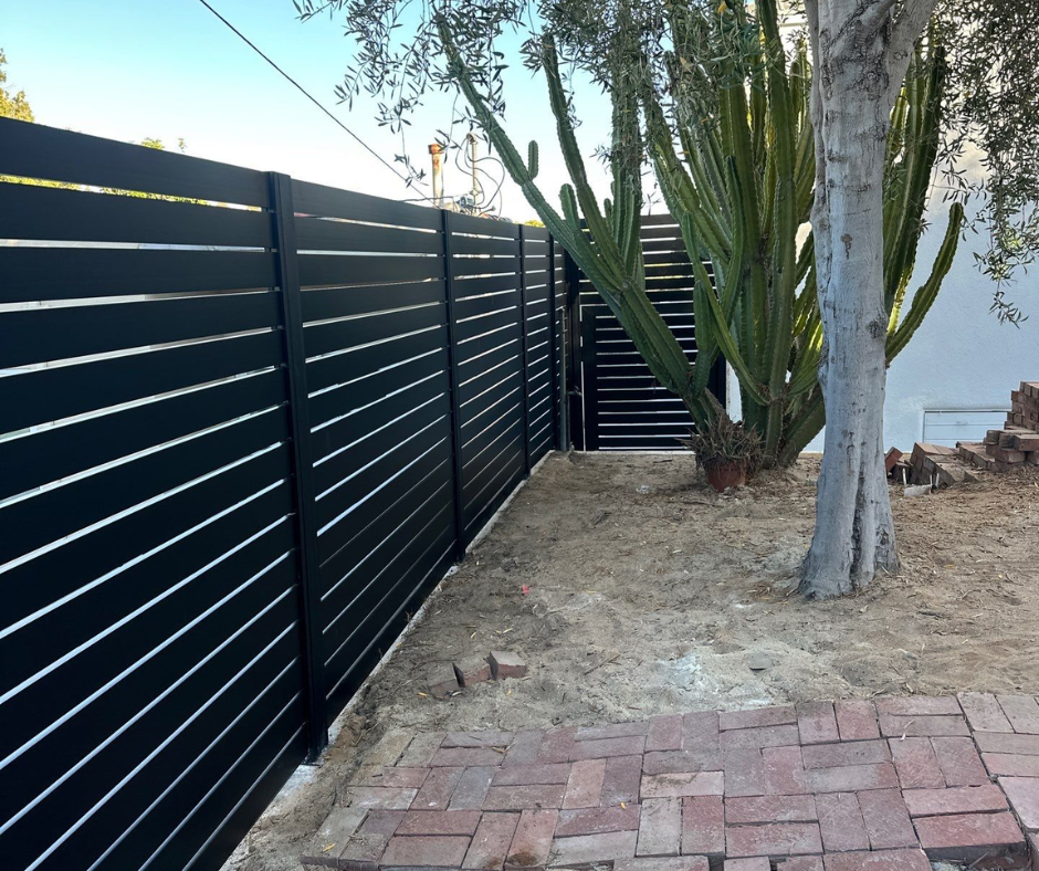 Profile 40 alu fence installed along landscaped garden with green backdrop