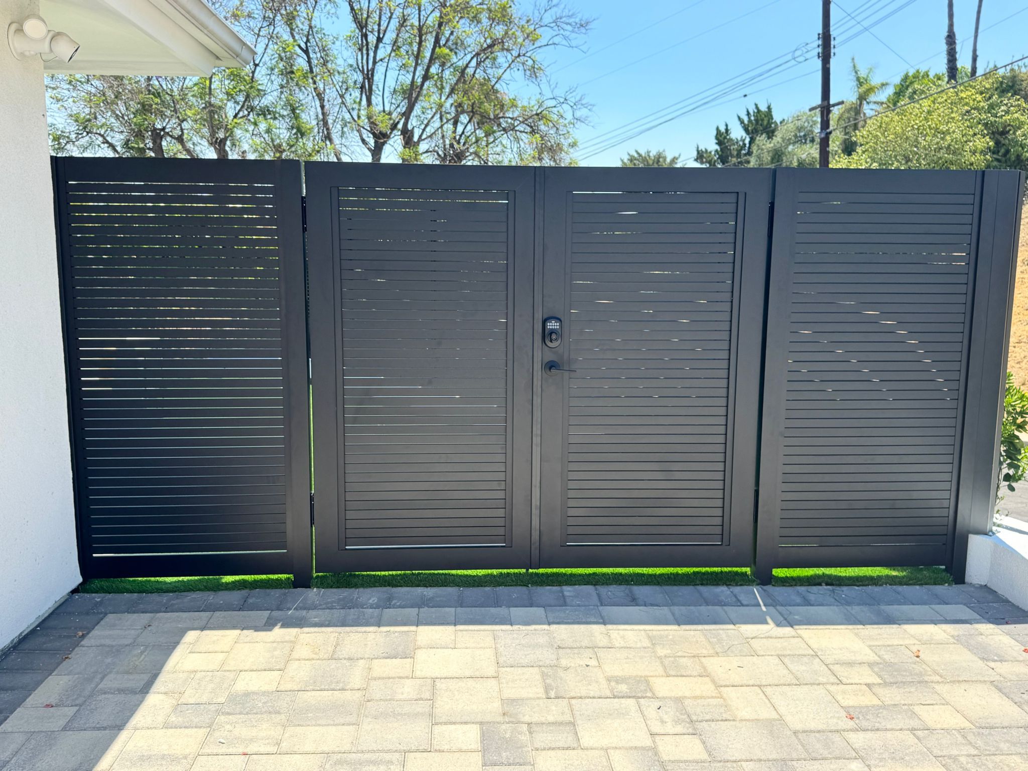 Real installation of Profile 20 aluminum driveway gate with brick pillar posts